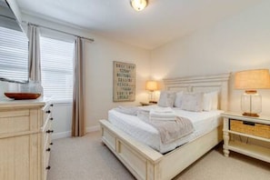 A bedroom with a bed, bedside tables, a dresser, and a wall-mounted artwork. - ECR7391 - Family Luxury Retreat + Pool @Encore! (Kissimmee)