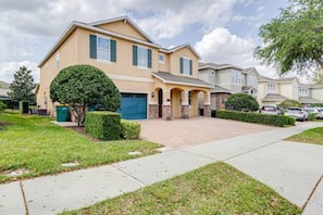 A residential house with a driveway, a garage, and a well-maintained lawn. - ECR641 - Stunning Dream Vacation+Theater @Encore (Kissimmee)