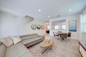 A modern living room with a sectional sofa, a coffee table, and a dining area with chairs. - ECR7701 - Family Oasis with private pool @Encore! (Kissimmee)