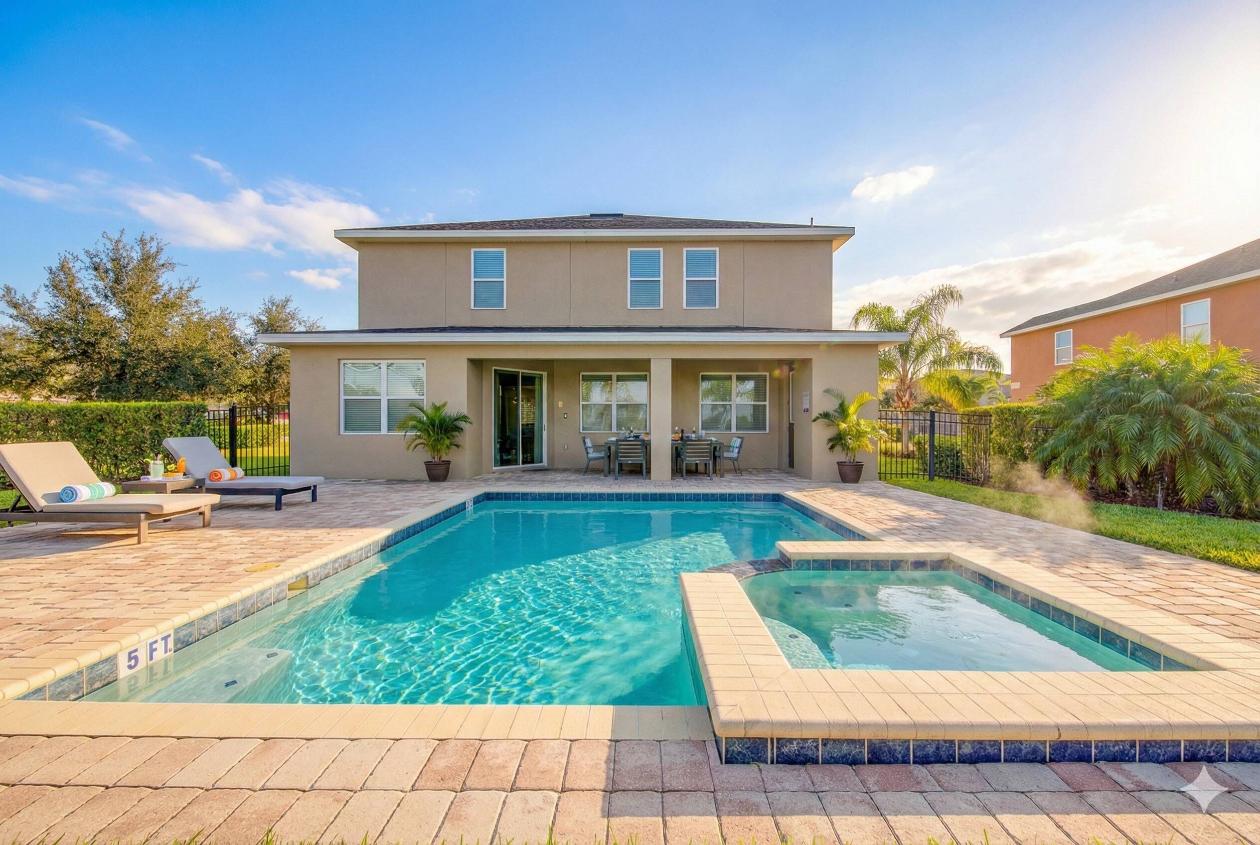 Une maison à deux étages avec une piscine et du mobilier de jardin.