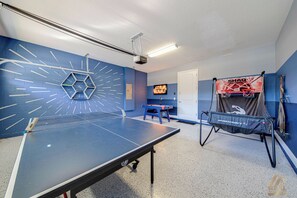 A ping pong table with a net, a wall clock, and a Star Wars themed wall decoration. - ECR7701 - Family Oasis with private pool @Encore! (Kissimmee)