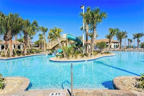 A swimming pool with a water slide, palm trees, and a clear blue sky. - Resort Access Vacation Retreat! | CG9327 (Davenport)