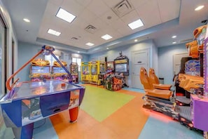 A room with arcade games, a pool table, and a large chair. - Resort Access Vacation Retreat! | CG9327 (Davenport)