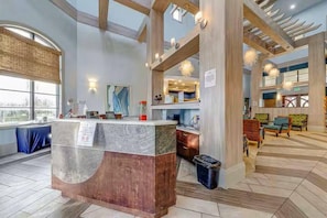 A hotel lobby with a reception desk, seating area, and large windows. - Resort Access Vacation Retreat! | CG9327 (Davenport)