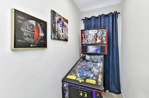 A pinball machine with a Star Wars theme, a framed poster of a planet, and a Star Wars movie poster on a wall. - ECR7676 - Bright Villa @Encore close from Disney! (Kissimmee)