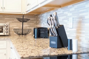 A kitchen with a granite countertop, a toaster, a black appliance, and a knife block. - WIR3753 - Family Resort Access Vacation @Disney (Davenport)