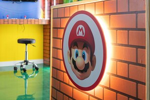A wall with a Mario character logo, a brick wall, and a yellow wall in the background. - ECR7609 - Enchanted Vacation Home @Encore (Kissimmee)