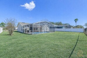 Ein Wohnhaus mit großzügiger, umzäunter Terrasse, Schwimmbad und eingezäunter Garten.