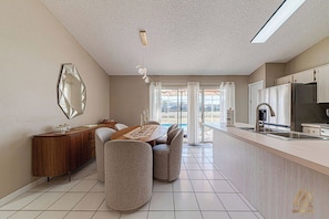A modern kitchen with a dining area, a large window, and a view of the outdoors. - RVH228 - Cozy Home with Pool, 3B Near Disney (Davenport)