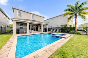 A modern residential building with a swimming pool, outdoor seating, and a well-maintained lawn. - ECR7783 - 4B Family Friendly Vacation @Encore! (Kissimmee)