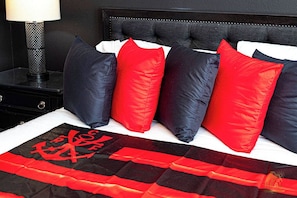 A bed with a black headboard, white bedding, and a red and black patterned throw. - Soccer Legend Zico’s Official Orlando Home | 8BR (Kissimmee)