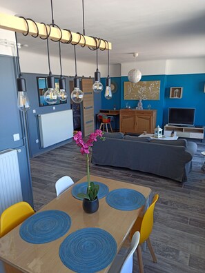 A modern living space with a dining area, kitchen, and seating area. - New Listing (Dunkerque)