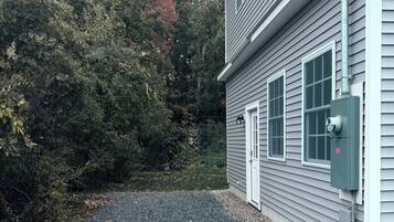 A house with a gravel driveway and a utility box near the entrance.