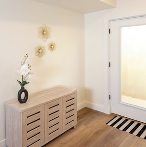 Eine Holzkonsole mit einer Blumenvase und drei Wanddekorationen.