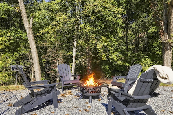 A fire pit with four Adirondack chairs arranged around it, set on a gravel surface with trees in the background. - 2 Miles to GSMNP- Hot Tub, Mtn Views, Fire Pit & Dog- Friendly + Fenced Dog Run (Sevierville)