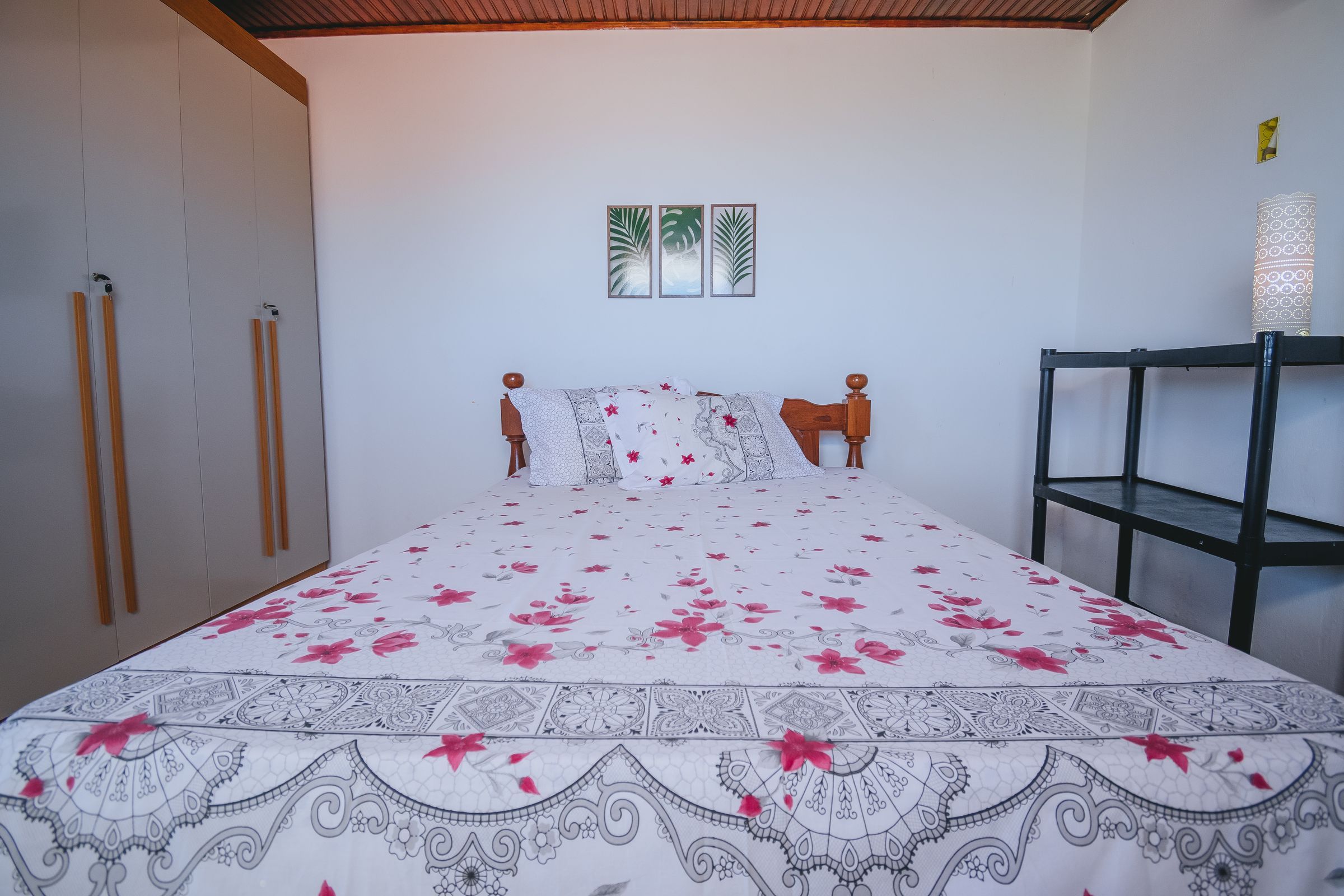 Une chambre à coucher avec un lit, une armoire et une étagère.
