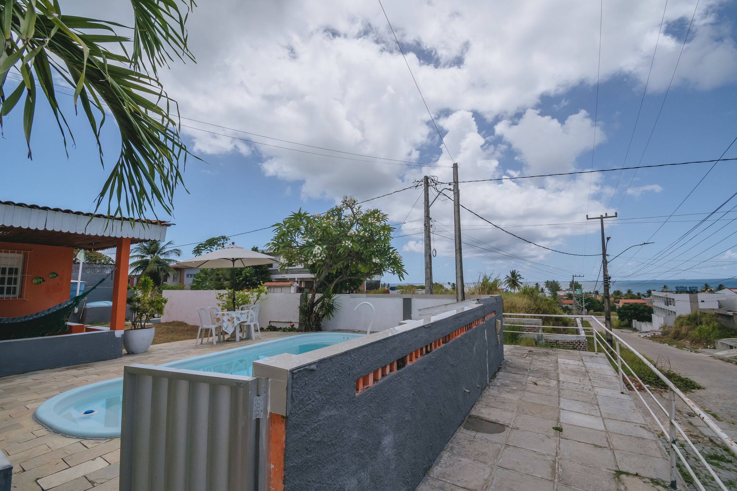 Un quartier résidentiel doté d’une piscine, d’un hamac et offrant une vue sur la mer.