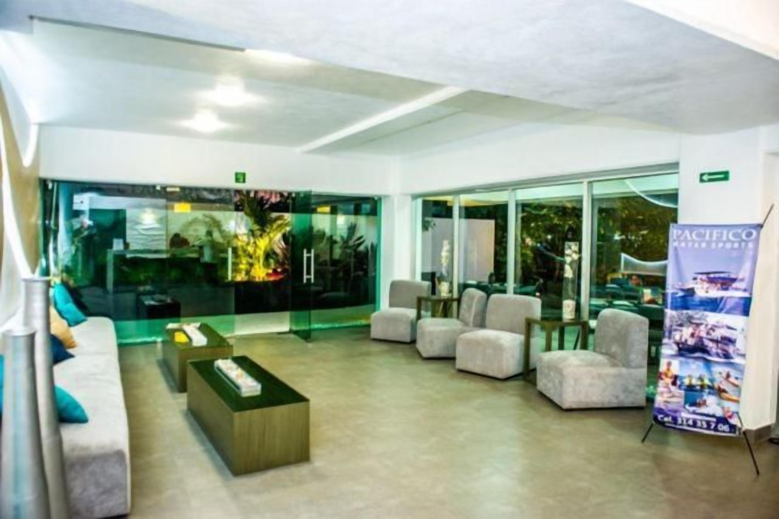 Um saguão com balcão de recepção, área de estar e parede de vidro com vista.