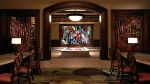 A dining area with a central table, chairs, and a large abstract painting on the wall. - Waikiki 2BR Paradise – Spacious Grand Waikikian Suite with Resort Pools & Beach (Honolulu)