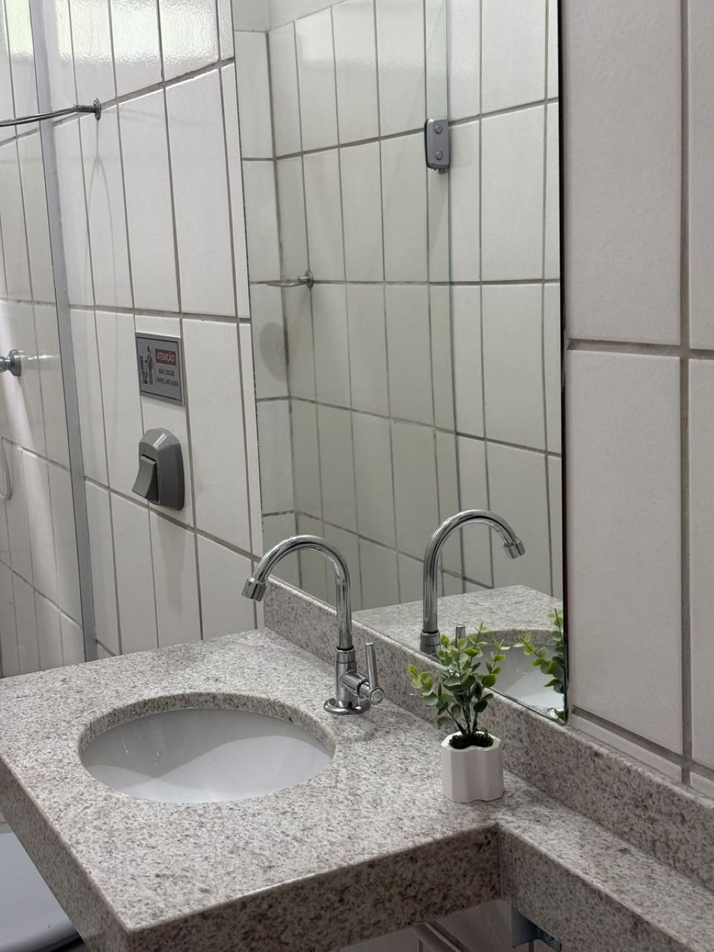 Un bagno con lavabo in granito, uno specchio e un asciugamani ad aria.
