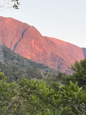 A mountainous landscape with dense vegetation and power lines. - Estância 3 por 1 (Guaratuba)
