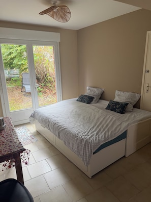 A bedroom with a bed, a table, and a chair. - New Listing (Récourt)