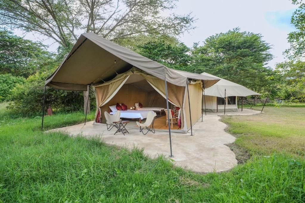 A tented accommodation with a dining area and a table set for two.