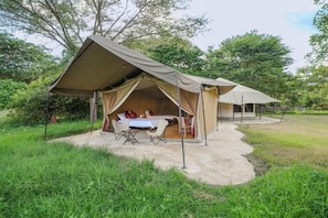 Ett tältliknande boende med en matplats och ett bord dukat för två personer.