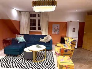 En stue med en sofa, et rundt sofabord og et tæppe med et mønster.