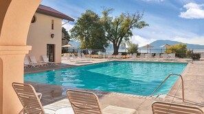 A swimming pool with lounge chairs and a view of mountains. - WorldMark Clear Lake - Lakeside 2BR with Boat Dock and Year-Round Heated Pool (Nice)