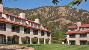 Un hôtel à plusieurs étages doté d’une cour intérieure et offrant une vue sur les montagnes.