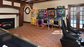 A room with arcade games, a fireplace, and a door with a window. - WorldMark Clear Lake - Lakeside 2BR with Boat Dock and Year-Round Heated Pool (Nice)