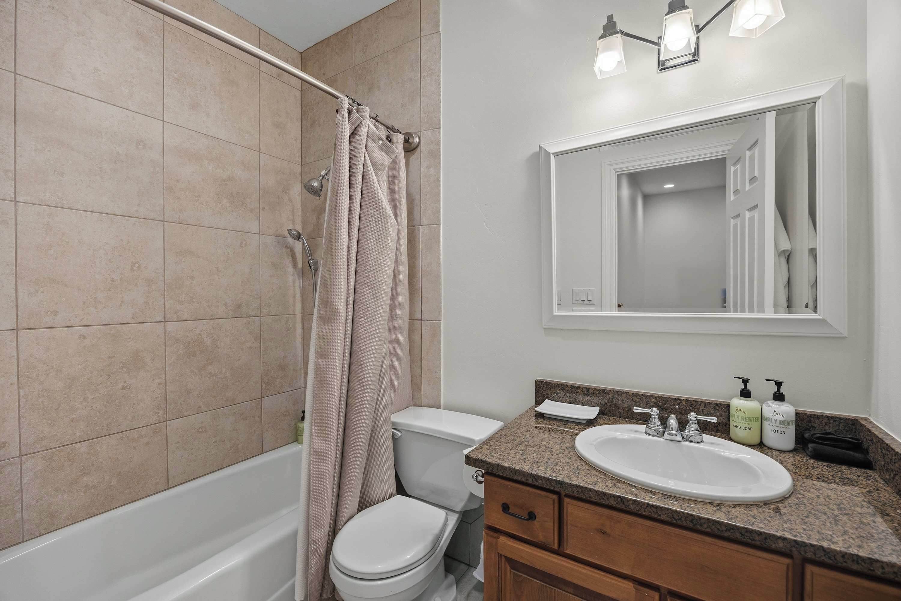 A bathroom with a bathtub, toilet, and sink.