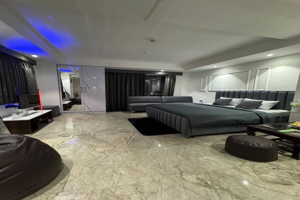 Een moderne slaapkamer met een bed, een zithoek en een televisie.