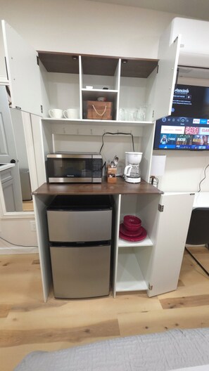 A compact kitchenette with a microwave, coffee maker, and a mini-fridge. - Private Patio Studio + Desk & TV near SAP Center (San Jose)