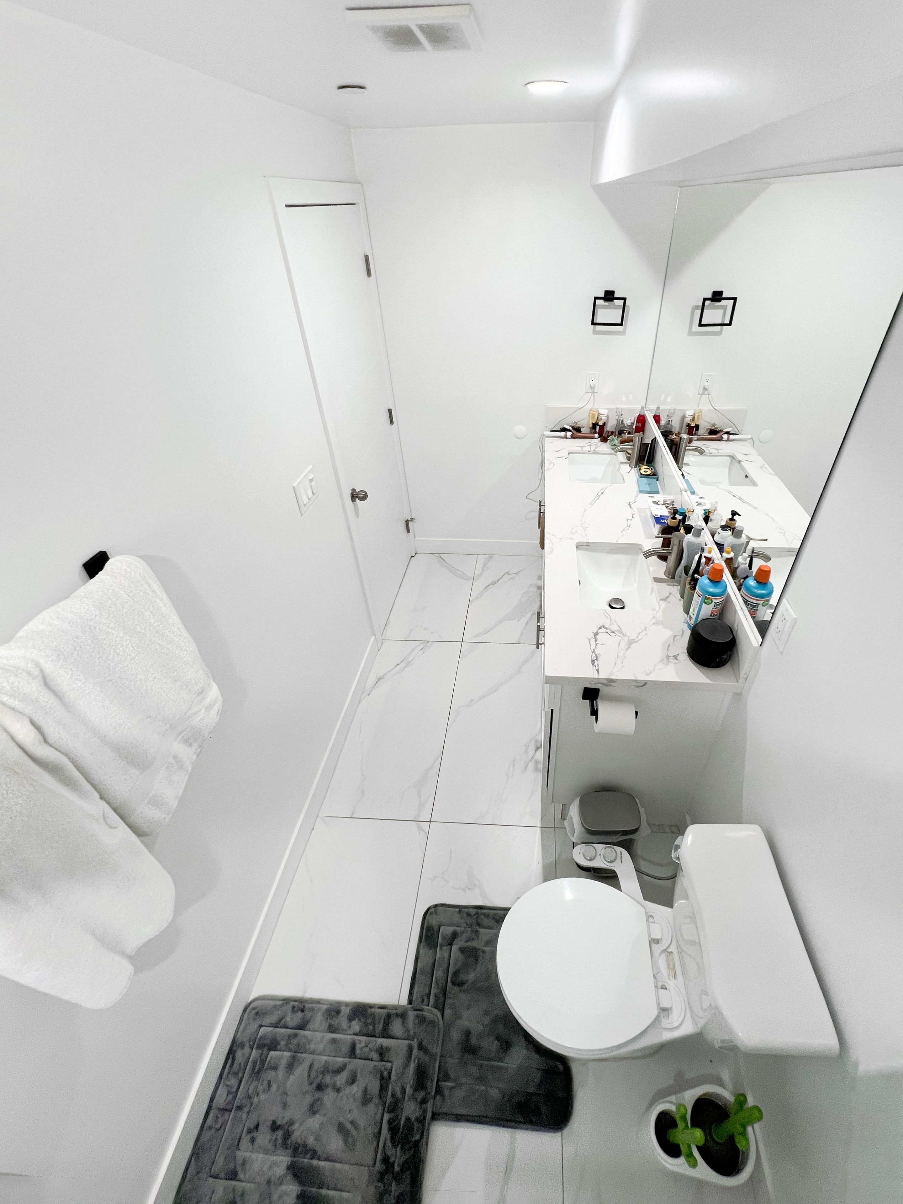 A modern bathroom with a white toilet, a sink, and a mirror.