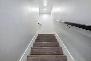 A staircase with wooden steps and white walls. - The Urban Vista Suite *Roof Top Patio Fun!* (Fort Worth)