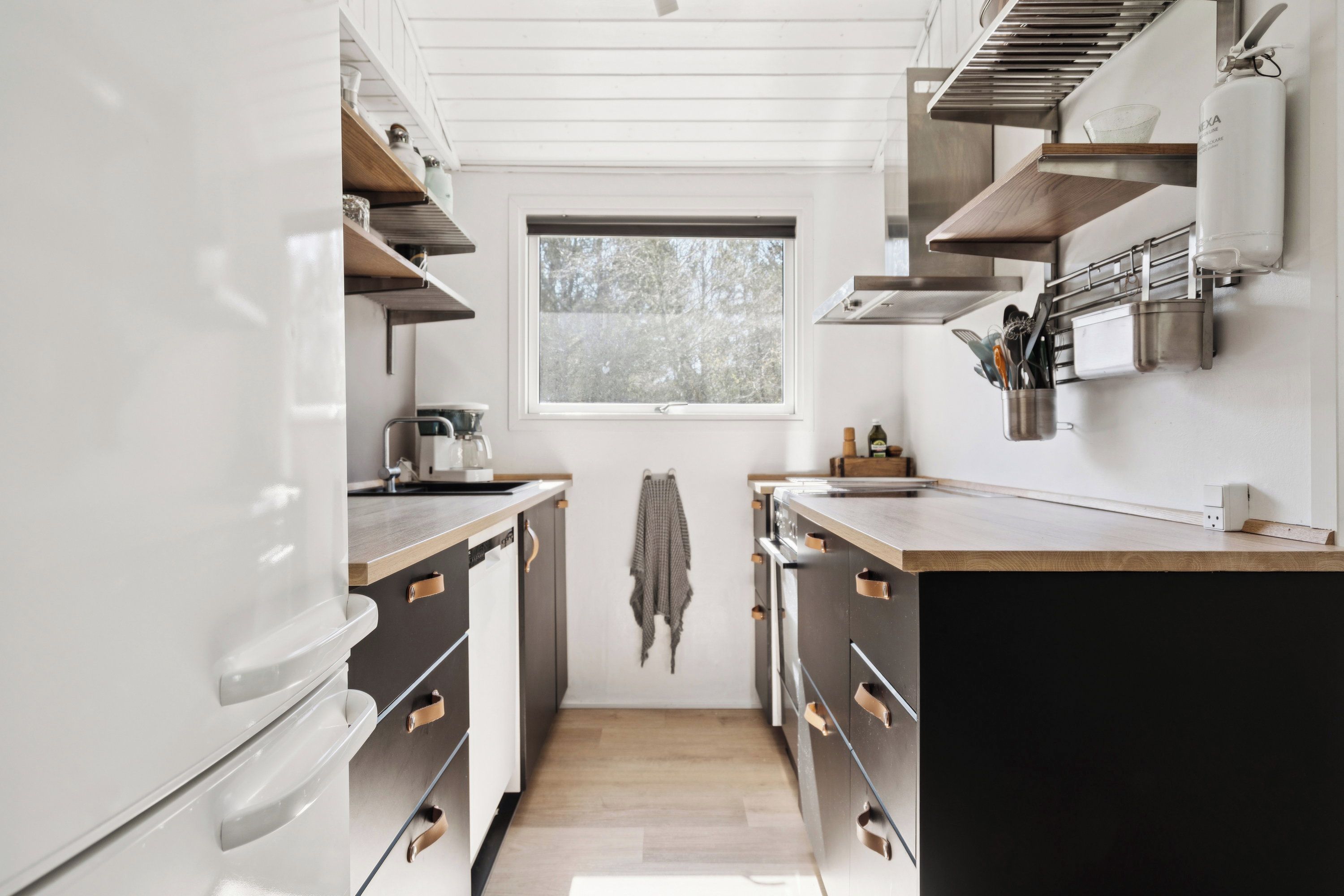 Una cocina moderna con encimeras de madera, electrodomésticos de acero inoxidable y un ventanal que proporciona luz natural.