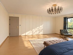 Una camera da letto con un letto grande, una sedia, un armadio e un lampadario.