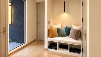 A hallway with a built-in bench, shoe storage, and a door leading to a balcony.