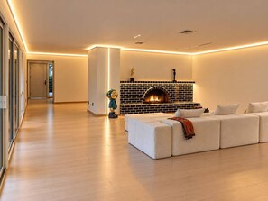 Un salon moderne avec une cheminée, un canapé blanc et un plancher en bois.