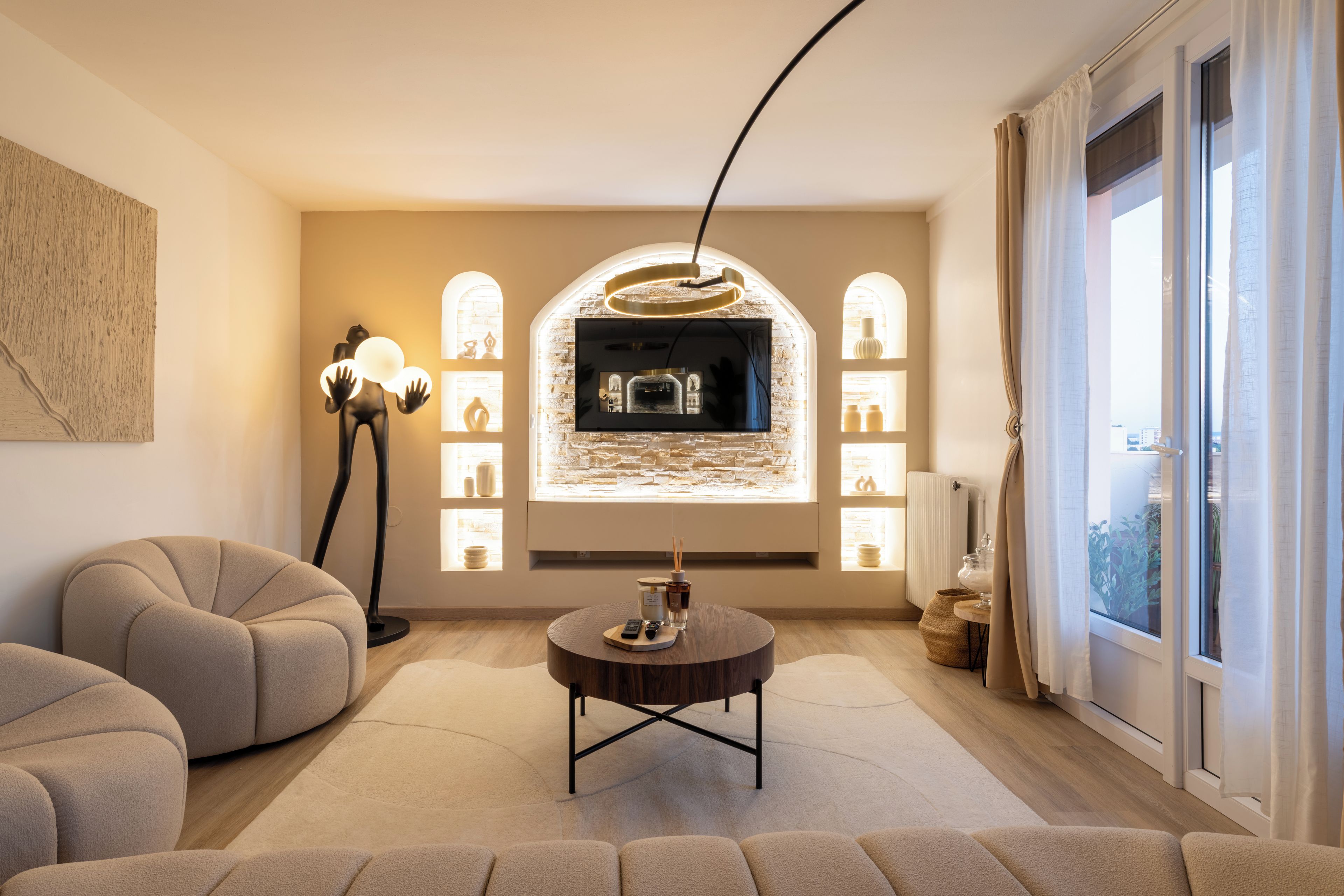 A modern living room with a fireplace, comfortable seating, and a view of the city.
