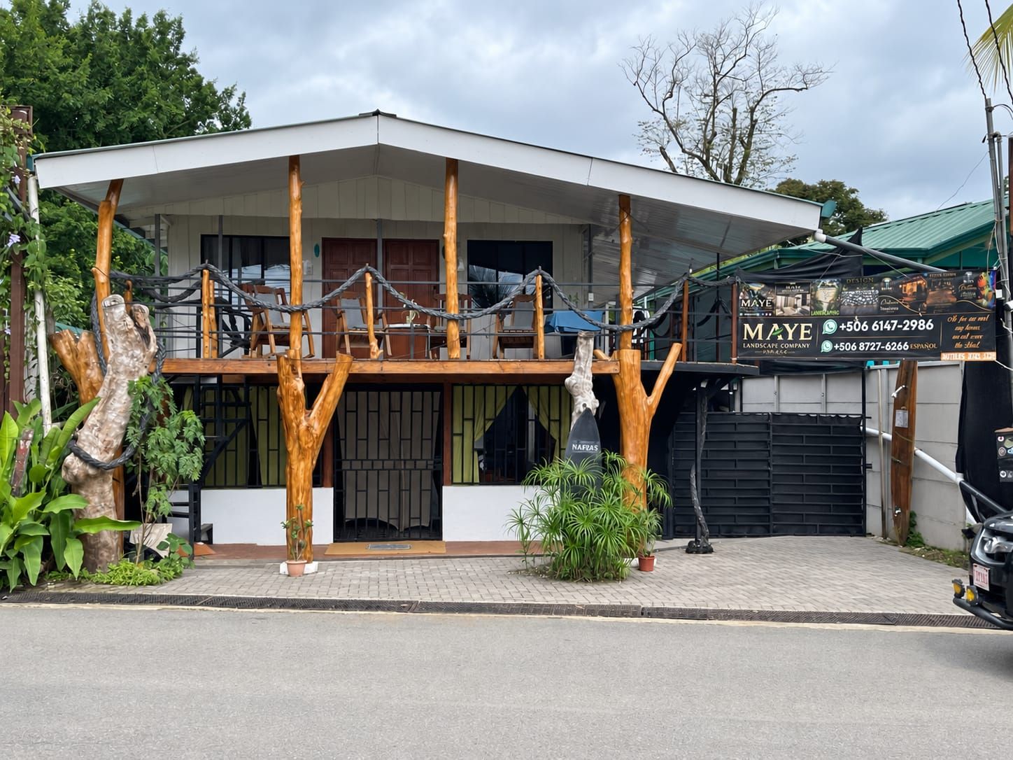 A modern building with a flat roof, large windows, and a covered entrance area.