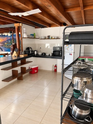 Una cocina con vigas de madera, una cafetera, un microondas y un enfriador rojo.