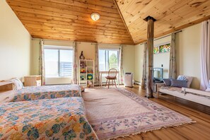 A cozy room with two beds, a desk, and a window with curtains. - Wonderful hilltop house with breathtaking views (Dorset)