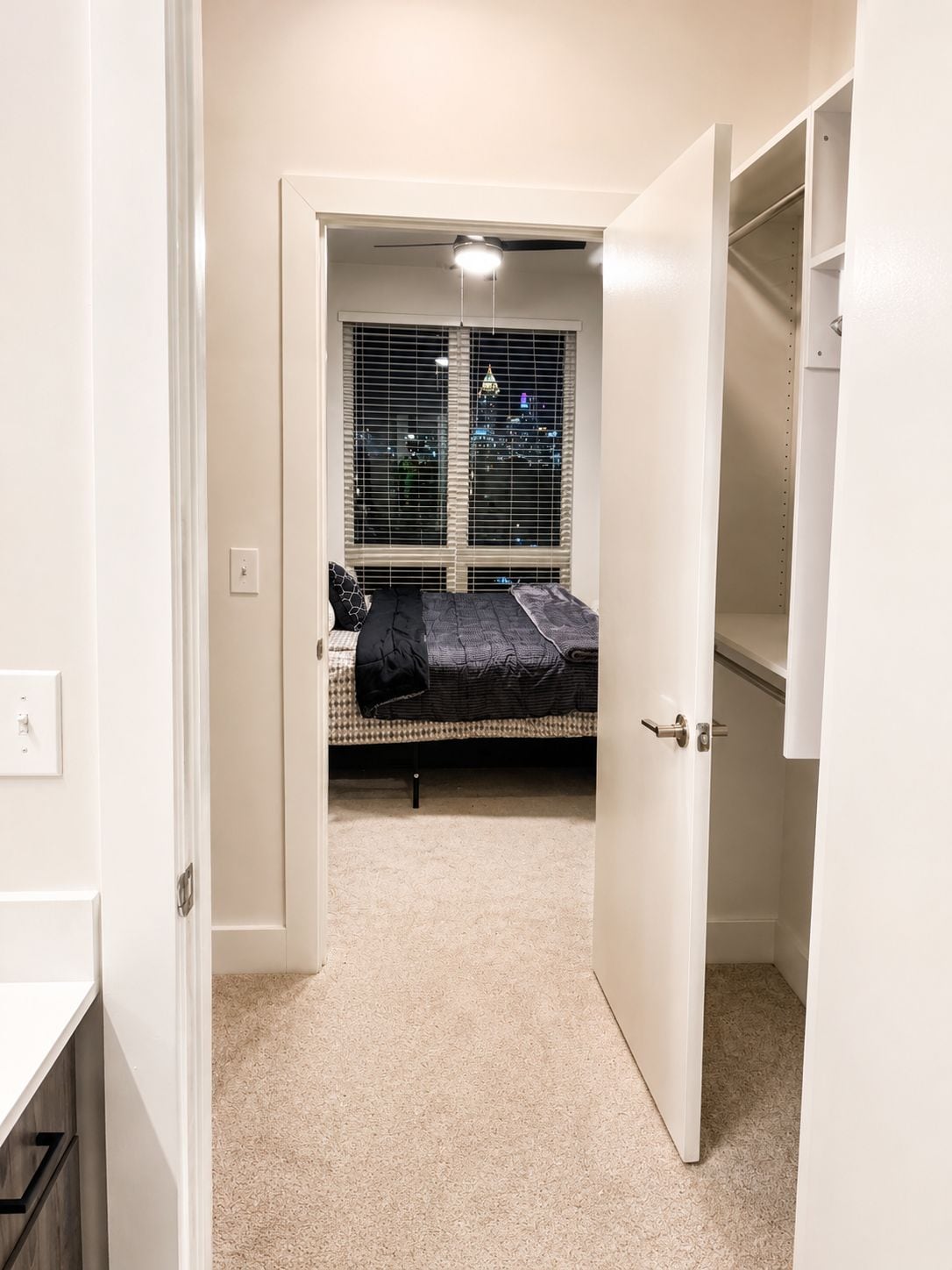 Ein Schlafzimmer mit einem Bett, einem Kleiderschrank und einem Fenster mit Jalousien.