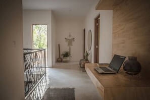 Ein modernes Interieur mit einer Holzbank, einem Laptop und einem dekorativen Spiegel.