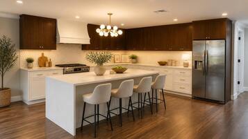 A modern kitchen with a central island, stainless steel appliances, and wooden cabinetry.