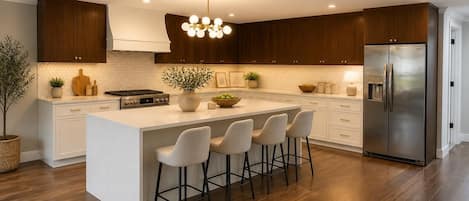 A modern kitchen with a central island, stainless steel appliances, and wooden cabinetry.