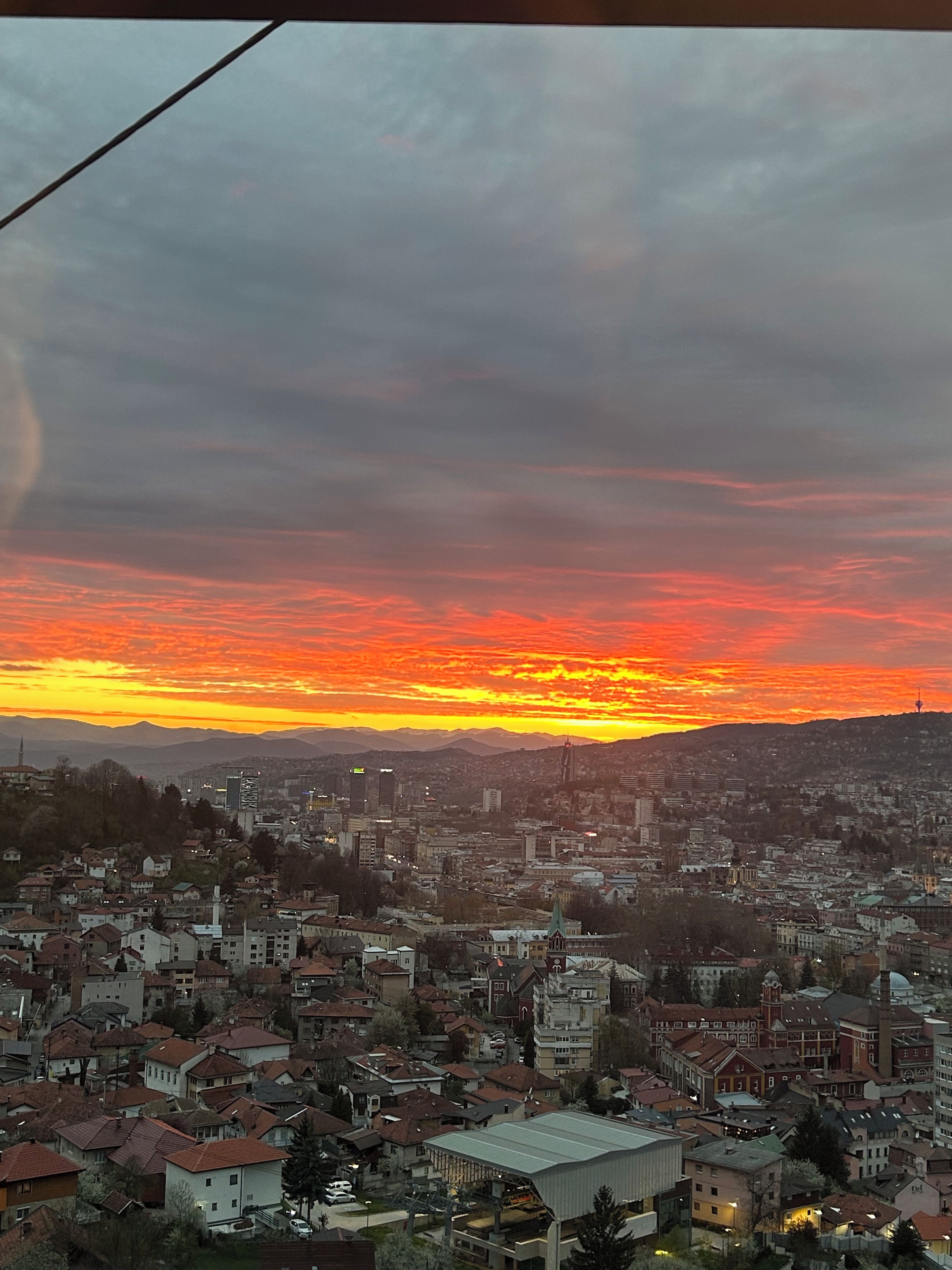 Een stadsgezicht in de zonsondergang met een mix van woon- en bedrijfsgebouwen.
